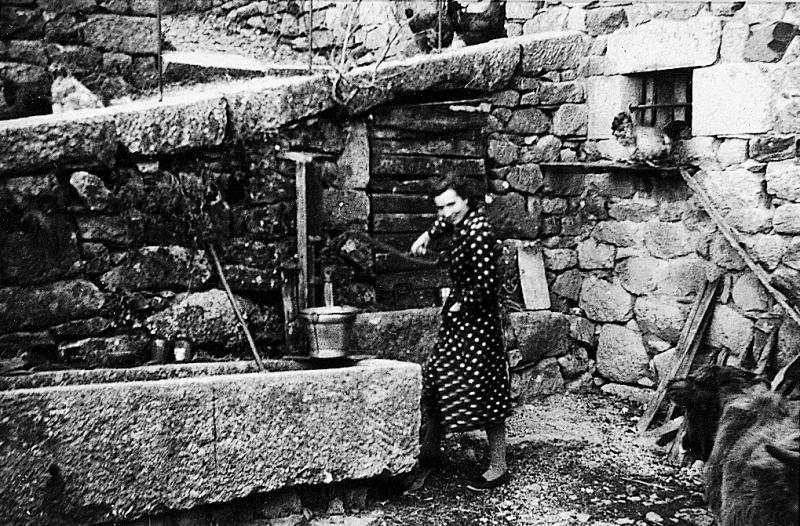 Femme pompant de l'eau à un puits (potz) ayant servi de cachette à un curé réfractaire, à Albès