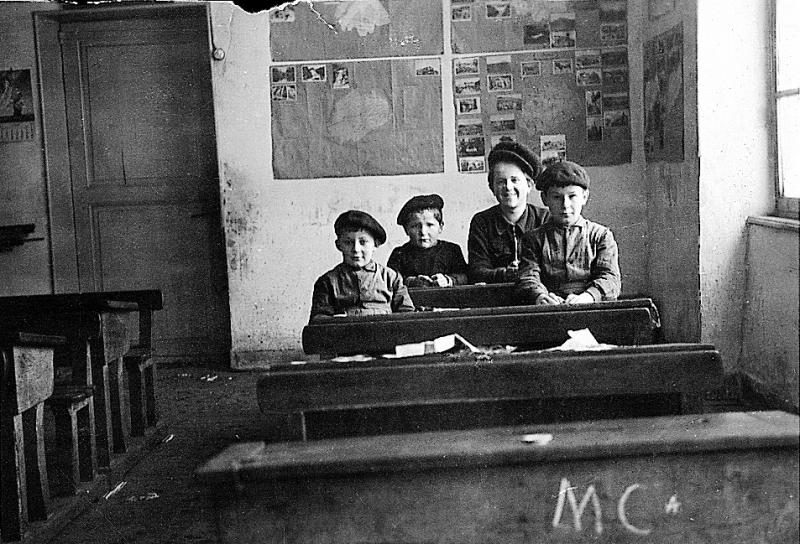 Quatre écoliers (escolans) avec béret dans salle de classe, vers 1951