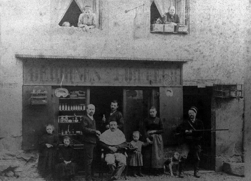 Barbier coiffeur (perruquièr) au travail devant son salon, rue du Valat, 1892