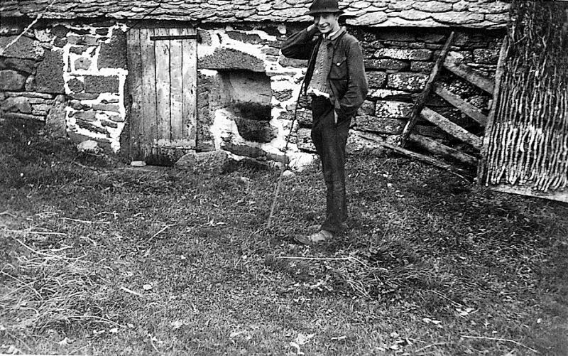 Jeune homme devant une porcherie (porcaría, sot) de buron (masuc), en Aubrac (secteur de Laguiole)