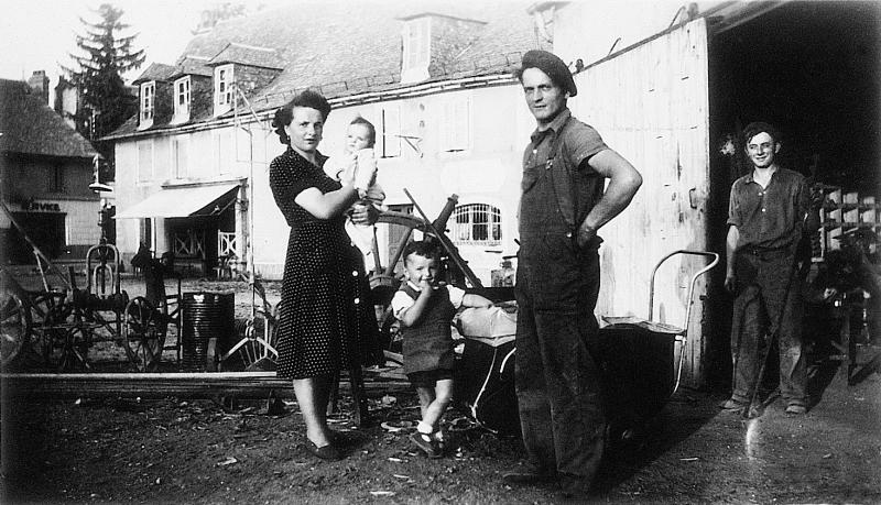 Famille Bras devant entrée de forge (farga) et dépôt de matériel agricole, 1949