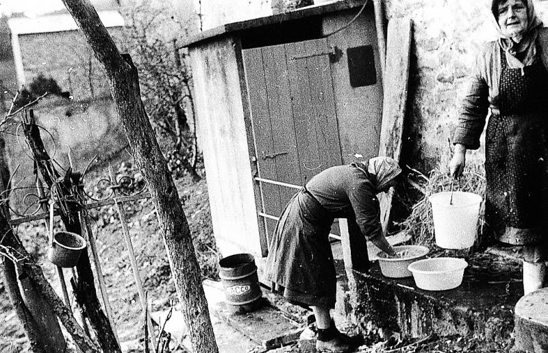 Abattage (masèl) du cochon (pòrc, tesson) : deux femmes nettoyant les boyaux (budèls), au Sotoul, 1970