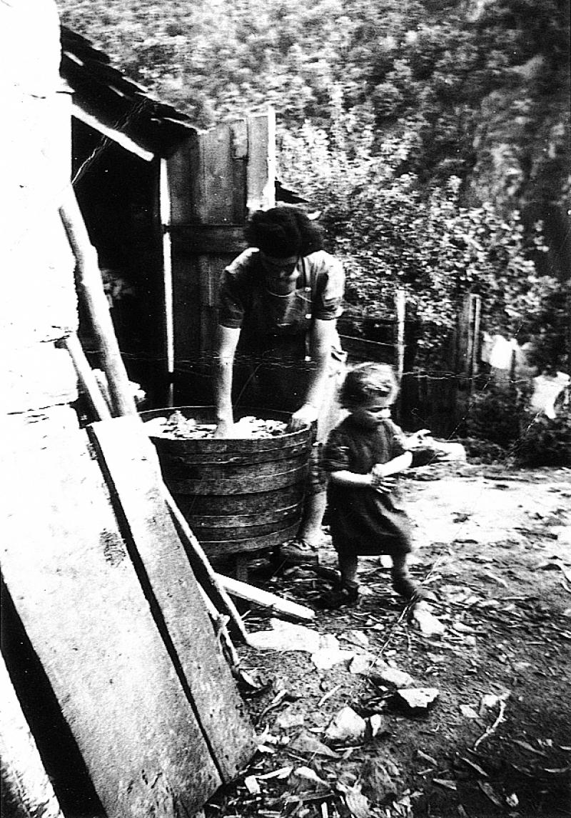 Femme faisant la lessive (bugada) dans un baquet (barquet) en bois, à Servoles