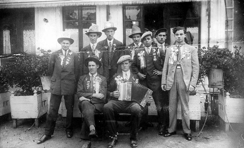 Conscrits et accordéoniste (acordeonista) devant une terrasse de café fleurie, 1932