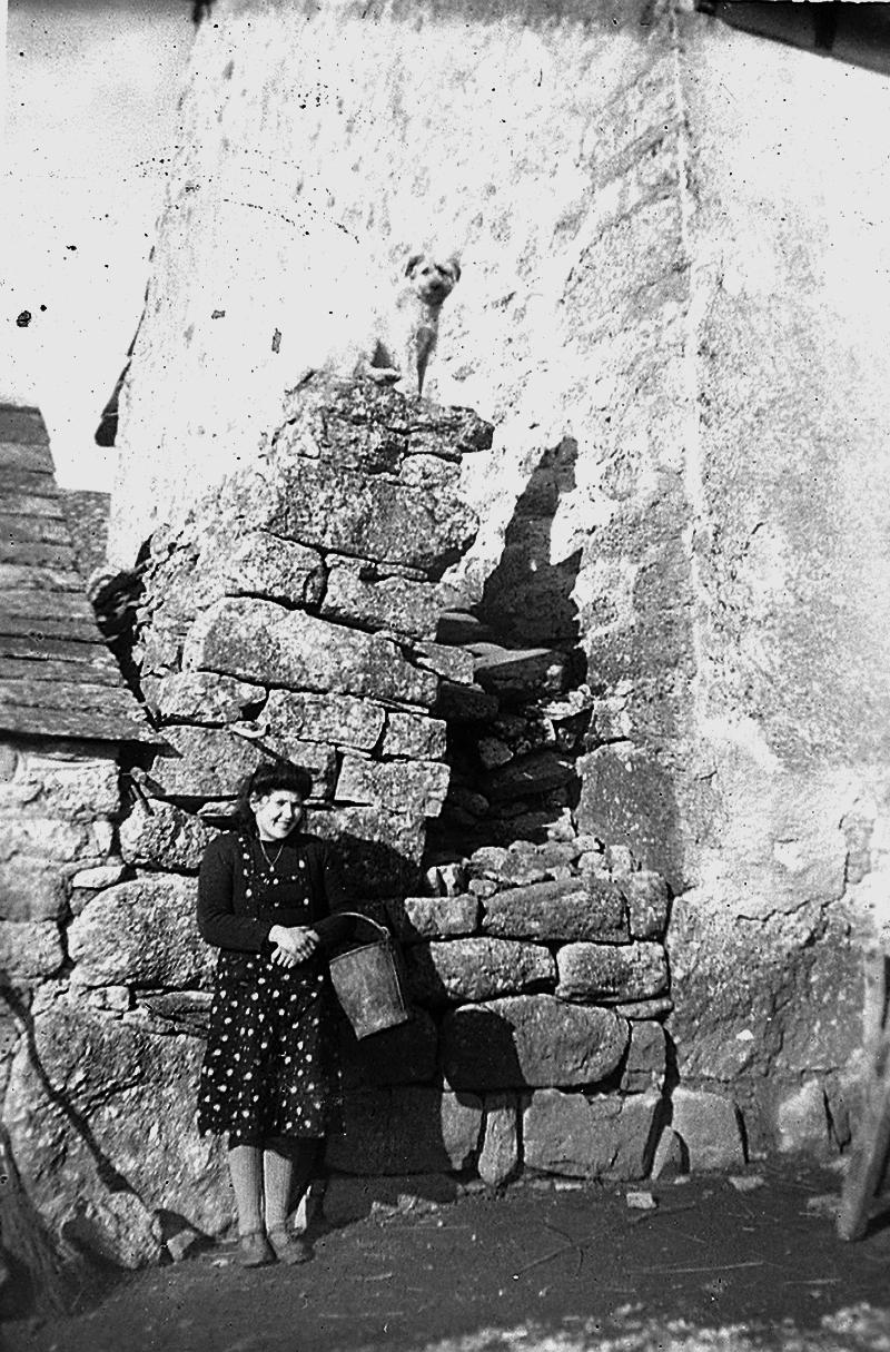 Femme avec seau (farrat ou ferrat) pour donner la pâtée (biure, pastada) aux cochons (pòrcs, tessons), à La Souque, 1946