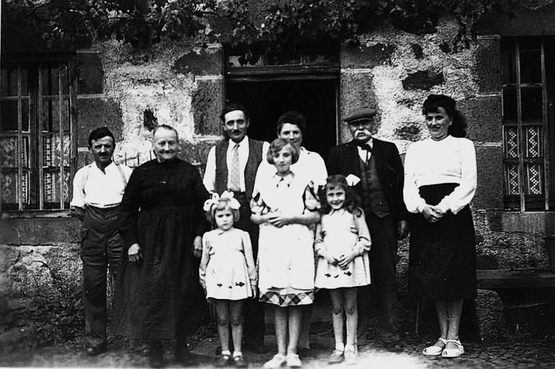 Famille devant porte d'entrée de maison, à Vines