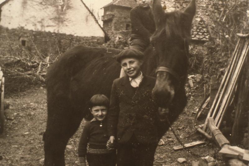Deux garçons avec équidé dans cour de ferme, au Gla, 1940-1941