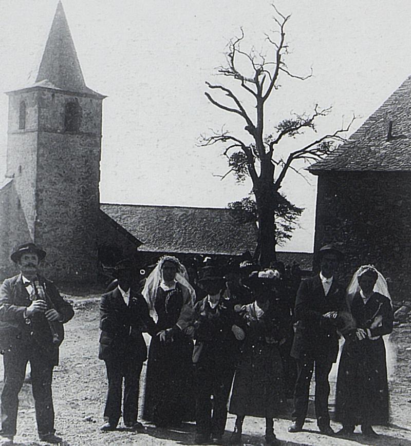 Double mariage avec joueur de cabrette (cabretaire) devant l'église (glèisa), à Bonnefon, vers 1910