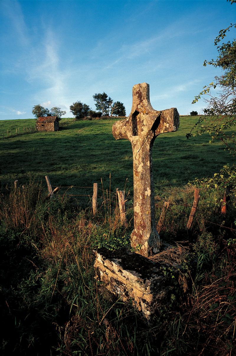 Croix (crotz) en pierre avec niche et séchoir à châtaignes (secador) au loin, en Ségala (secteur de Baraqueville-Sauveterre)