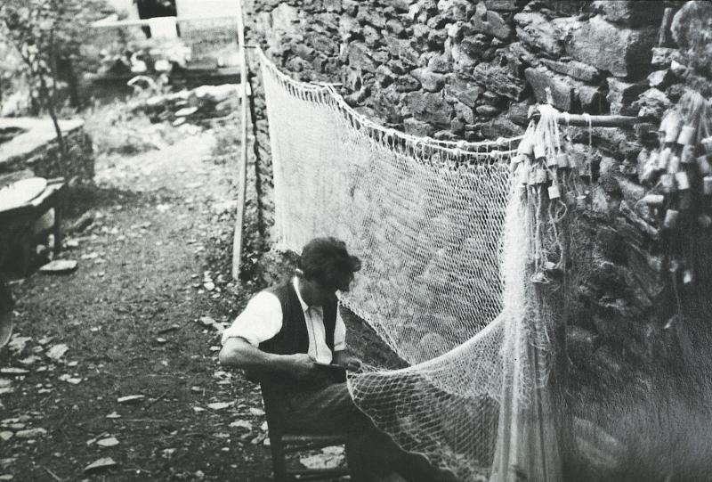 Homme réparant un filet (fialat, tèla) de pêche, à Montarnal