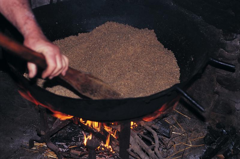 Fabrication de l'huile de noix (òli de nose) : chauffage des cerneaux (nogalhs) broyés, au Mas de Marcot, janvier 1996