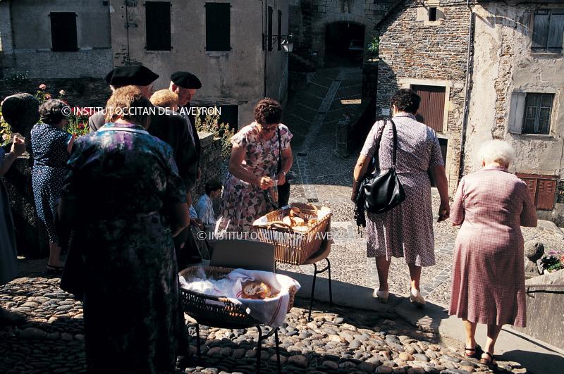 Paroissiens (parroquians) prenant du pain bénit (pan senhat) pour la Saint-Fleuret (Sant-Floret), juillet 1994