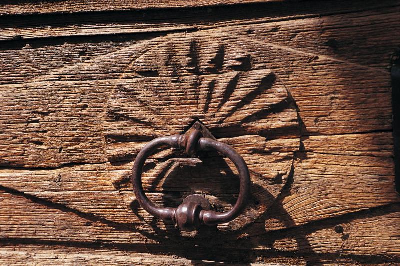 Poignée en fer sur panneau en bois sculpté de porte d'entrée, secteur de Laissac, avril 1999