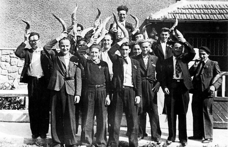 Jeunes hommes avec cornes (còrnas, banas) au-dessus de leur tête à la fête des mariés de l'année (cornards), 1946