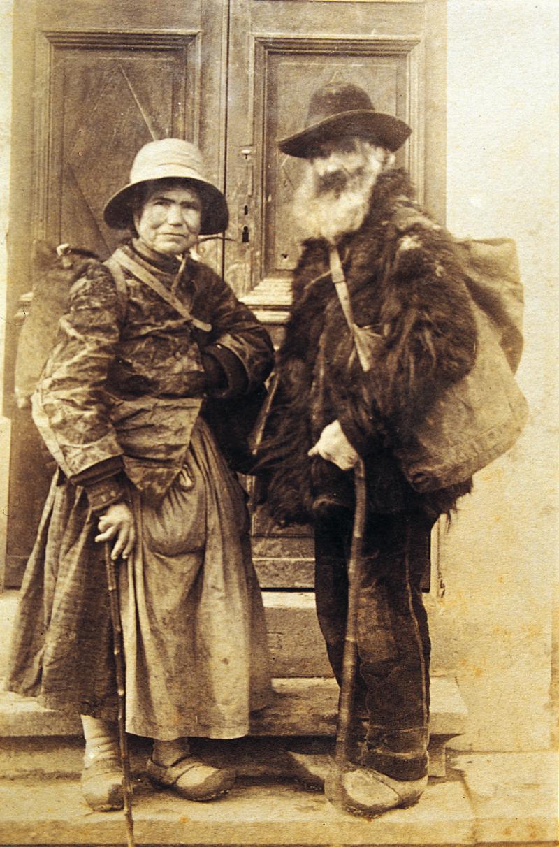 Couple de mendiants (paures) devant la porte de l'usine Reynès, à Lapeyre, vers 1900