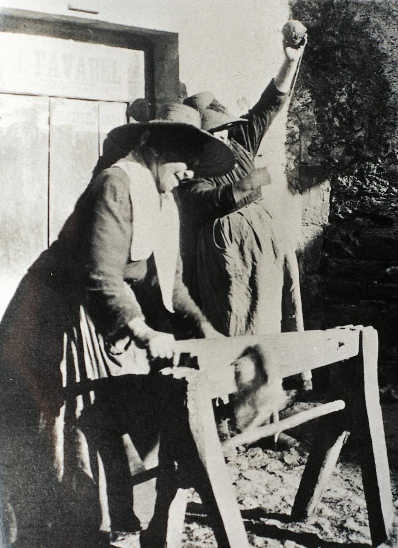 Femme broyant du chanvre (cambe, cambi) avec une broie (barga) et une autre réalisant une pelote