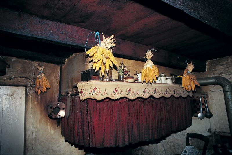 Quatre bouquets (finèlas, pinèlas) d'épis (espigas) de maïs (milh) suspendus à une poutre (fusta) et divers objets sur tablette (fusadièr) de cheminée (canton), à Vidalou, mars 1995