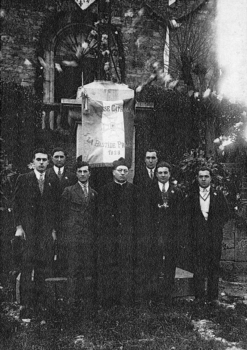 Six jeunes hommes de la Jeunesse catholique avec un curé (curat) devant une bannière (banièja), 1928