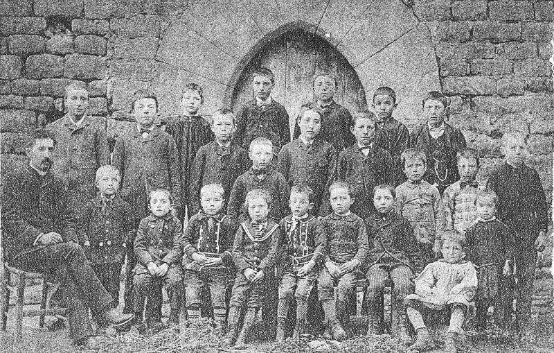 ​Ecole (escòla) des garçons devant une porte ogivale, à Versols, vers 1892