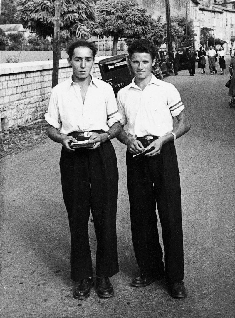 Deux jeunes hommes du comité des fêtes dans la rue un jour de fête (fèsta, vòta), 1953