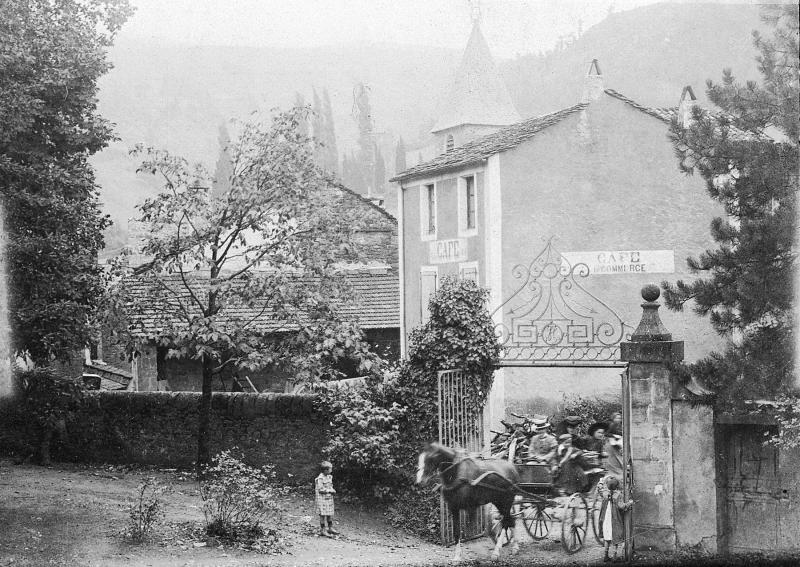 ​Equidé attelé à une jardinière (jardinièira) transportant une famille passant sous un portail (portal) et façade de café, à Lapeyre, 1905