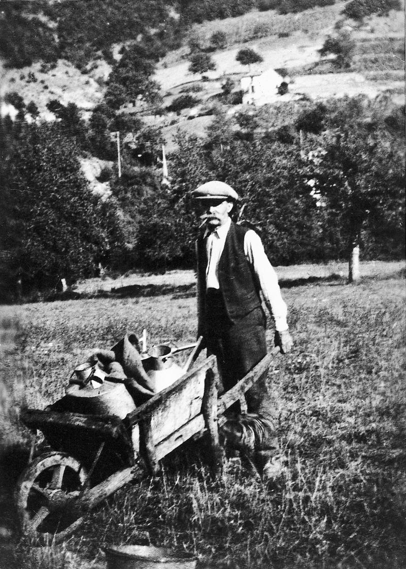 Homme transportant trois arrosoirs avec une brouette (carriòl), au Couat, 1948