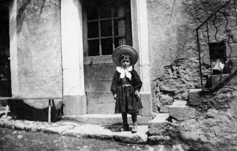 Enfant devant une porte d'entrée de maison (ostal)