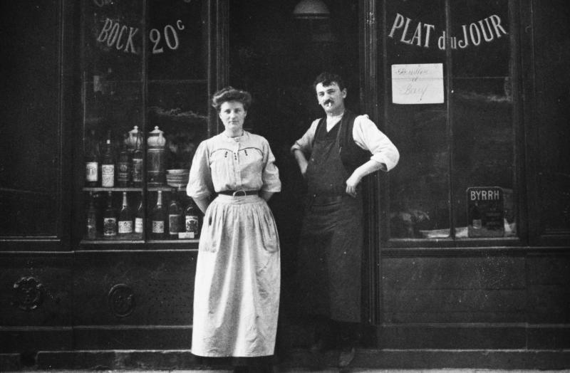  Femme et homme sur le pas de porte d'un débit de boissons, restaurant, à Paris (75) ou sa région