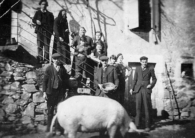 Famille dans les escaliers (escalièrs) d'une maison (ostal) et cochon (pòrc, tesson), à La Rode