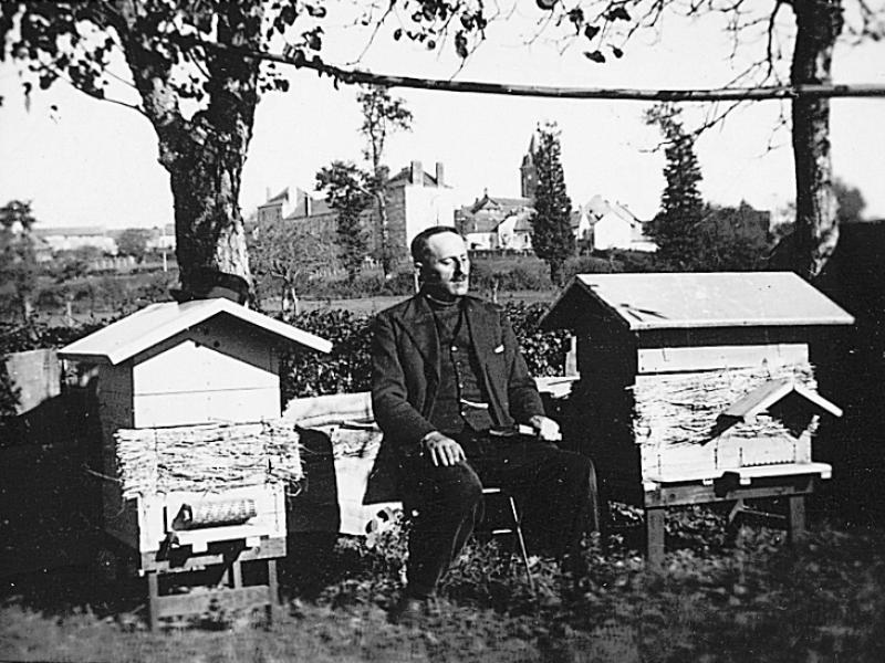 Homme assis devant deux ruches (bornhons), à La Garrigue, vers 1940