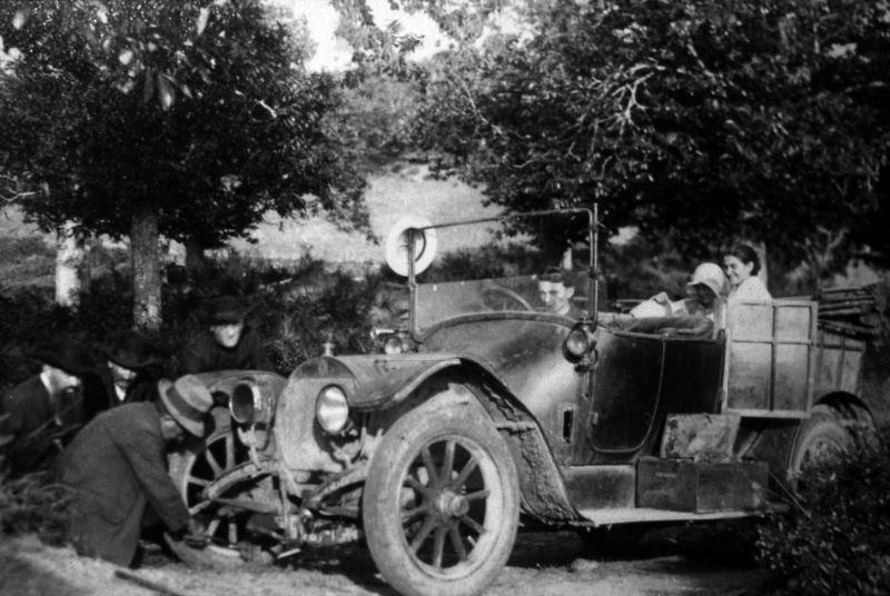 Homme soulevant une automobile avec un cric, dans le Naucellois (secteur de Naucelle)