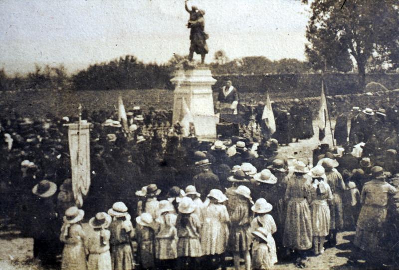 Villageois (vilatjors), curé (curat) et écoliers (escolans) rassemblés autour du monument aux morts pavoisé