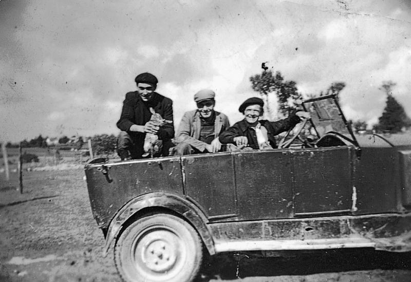 Trois hommes, dont un montrant un lapin, dans une voiture (veitura), 1950