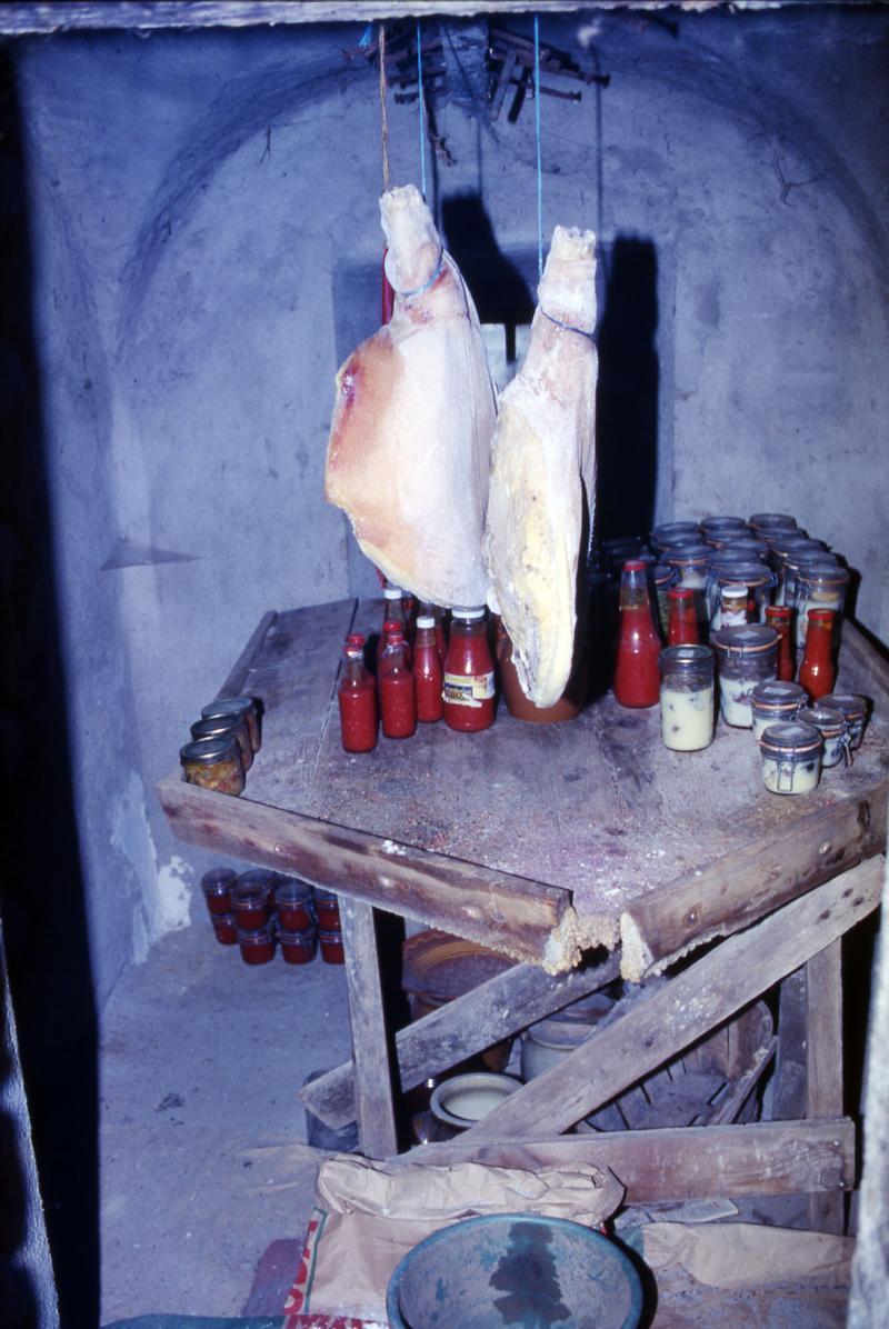 Deux jambons (cambajons) suspendus séchant, conserves entreposées sur ou sous un saloir (cleda, salador), dans le Naucellois (secteur de Naucelle), juin 2000