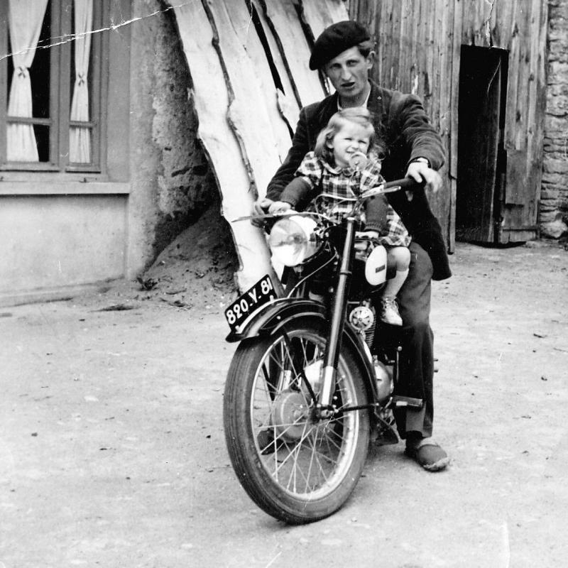 Fillette et jeune homme sur une motocyclette