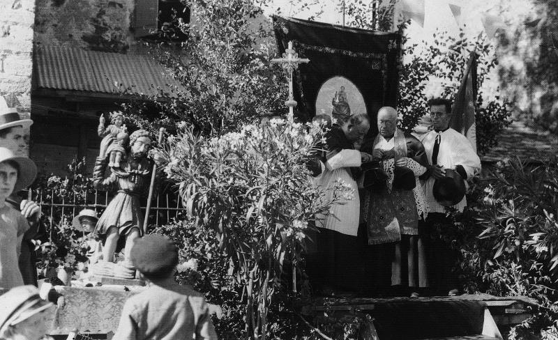 Paroissiens (parroquians), statue (estatua) de saint Christophe et curés (curats) sur une estrade (empont) fleurie, à La Merette, vers 1928