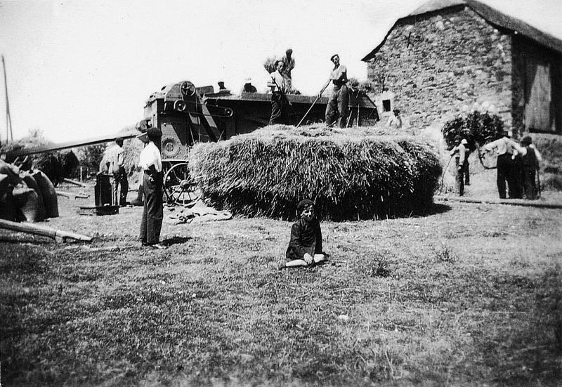 Temps de pause durant dépiquage (escodre) mécanisé à la batteuse (batusa) devant une grange (fenial, granja), à Jouels, août 1940
