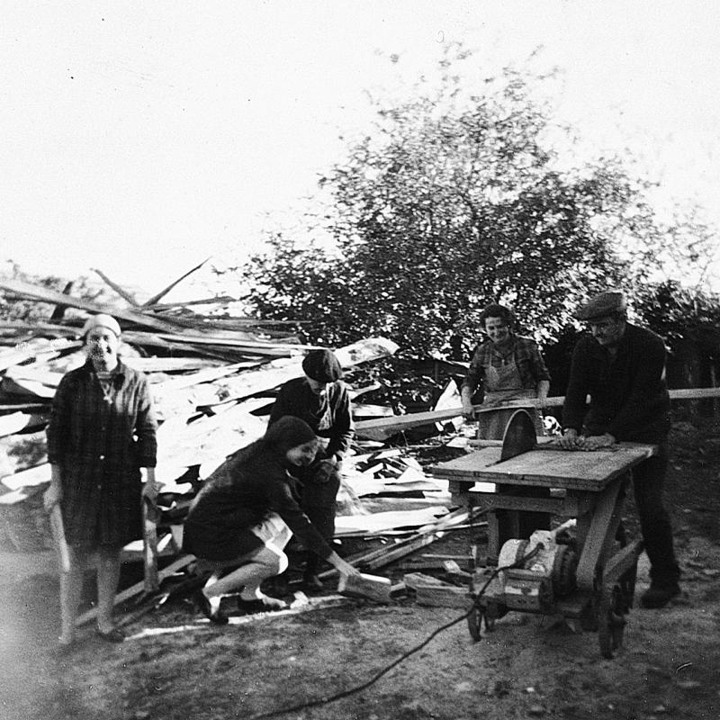 Famille sciant avec une scie circulaire des chutes de bois d'œuvre (fust) pour en faire du bois de chauffage (lenha)