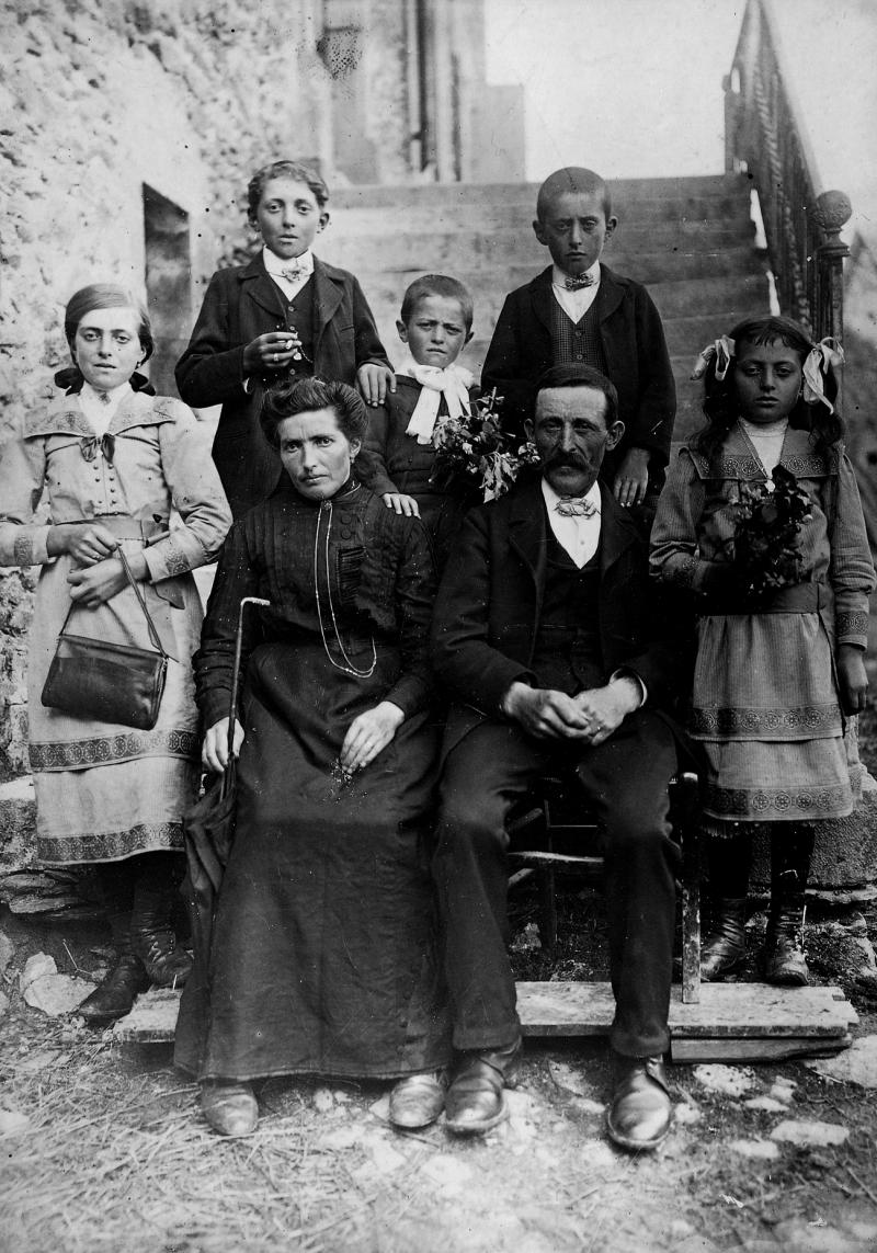 Couple avec cinq enfants (dròlles, enfants) en bas des escaliers d'une maison (ostal), à Sever, 1914