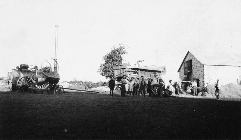 Temps de pause après dépiquage (escodre) mécanisé avec une batteuse (batusa) actionnée par une locomobile (caufusa) devant une grange (fenial, granja), à Bigergues, 1945-1950