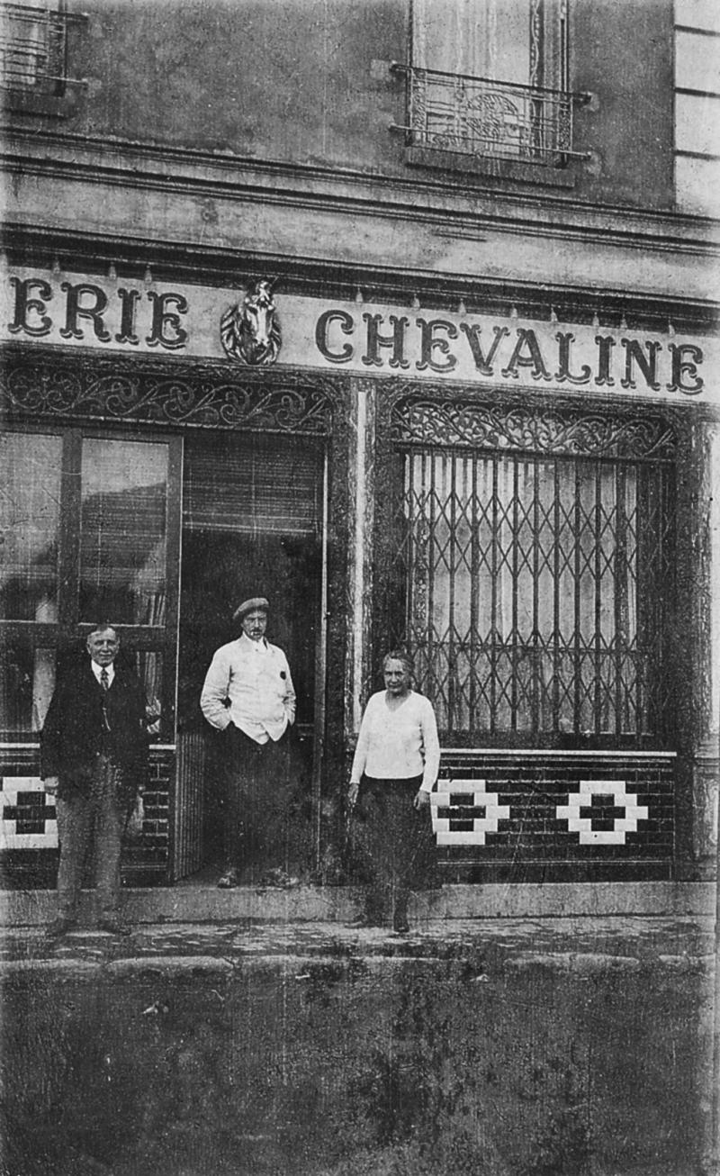 Deux hommes (òmes), dont un boucher (bochièr), et une femme (femna) devant une boucherie chevaline, à Paris (75)