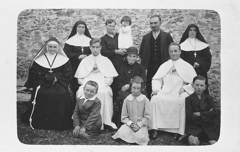 Famille avec trois religieuses (sòrres, surs) et deux curés (curats) en soutane réunie pour la première messe de l'un des deux, à Rhodes, 1936