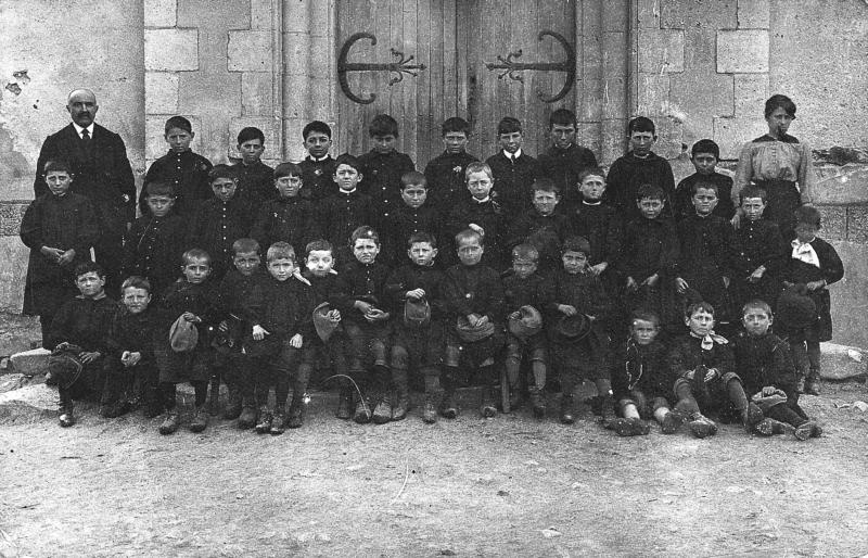 Ecole (escòla) des garçons devant la porte de l'église (glèisa), avant 1914