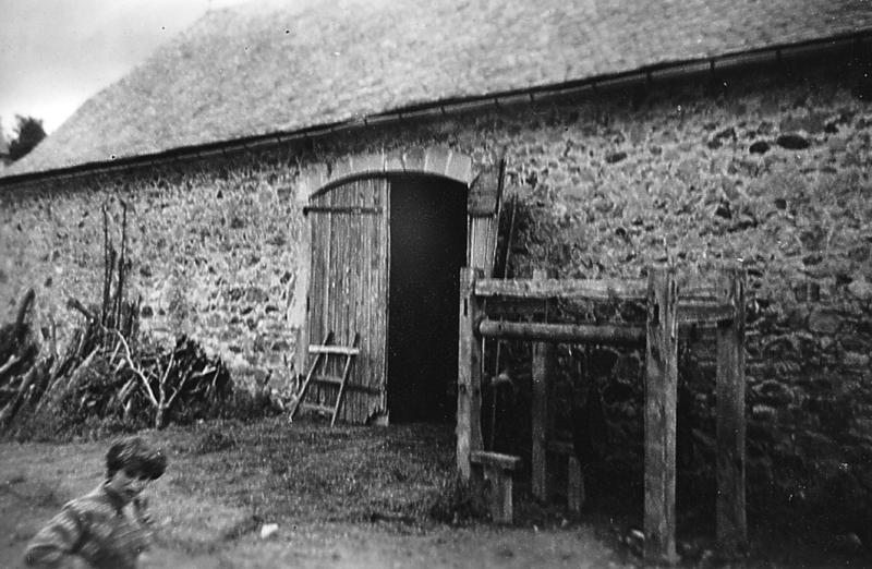 Bois de chauffage (lenha) et travail à ferrer (congrelh, trabalh) devant un portail (portal) de grange (fenial, granja), à Tizac, 1955