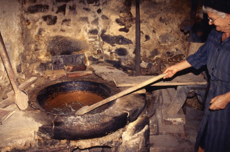 Femme mimant la chauffe des cerneaux de noix (nogalhs) dans une poèle (padena) en cuivre (coire), octobre 1998