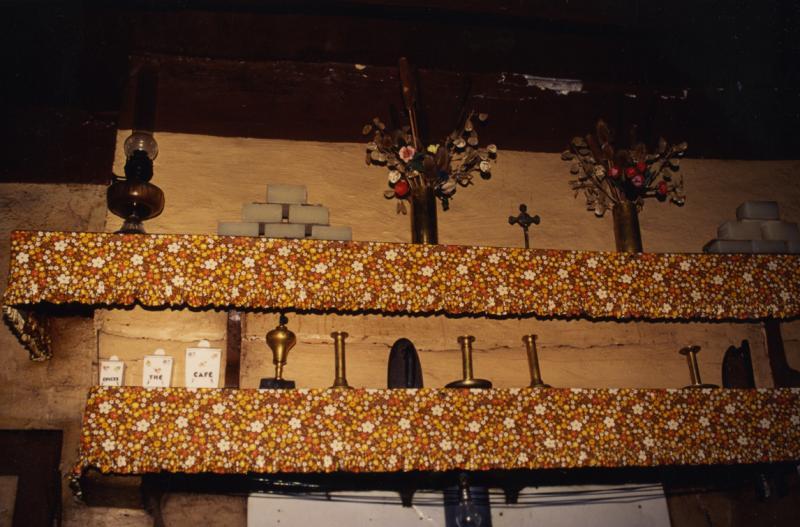 Divers objets exposés sur deux étagères (estatgièiras, fusadièrs) d'un coin de feu (canton), en Ségala (secteur de Rieupeyroux), 1998