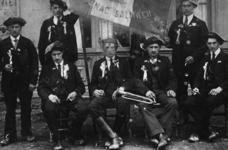 Conscrits, dont un avec un clairon (claron), devant une devanture (veirina), à Carcenac Salmiech, classe 1922