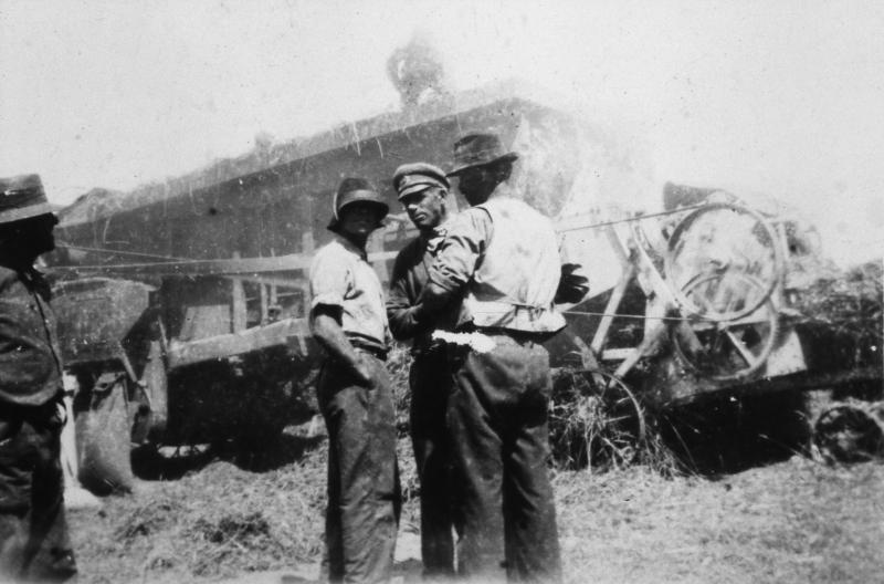 Hommes discutant devant une batteuse (batusa), au Suc, 1945